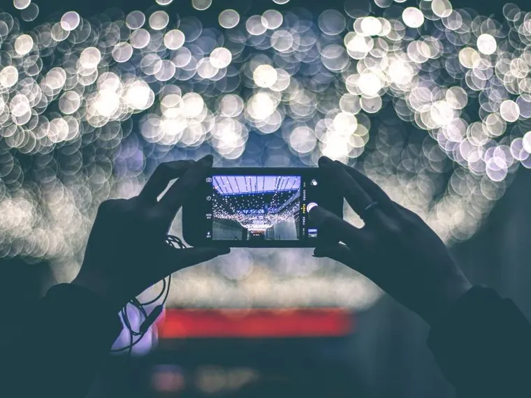 Mãos com celular e câmera